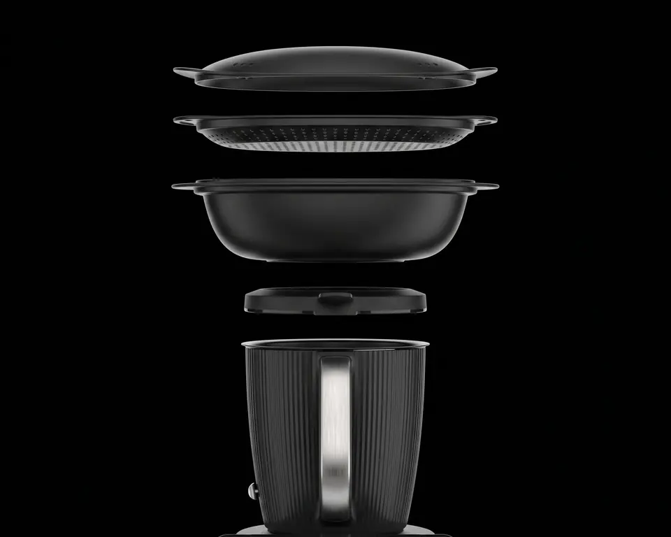 Thermomix TM7’nin parçaları siyah bir zeminde üst üste ayrılmış olarak: en üstte Varoma® kapağı, altında Varoma® tepsisi ve kabı, sonra kapak başlığı ve en altta çelik tutamaklı karıştırma kabı.